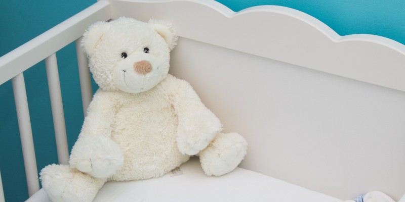teddy bear in baby crib